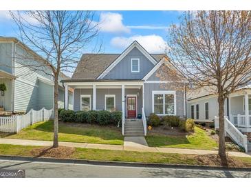 Charming home featuring a welcoming front porch, well-maintained lawn, and red front door at 5124 N Pratt St, Covington, GA 30014