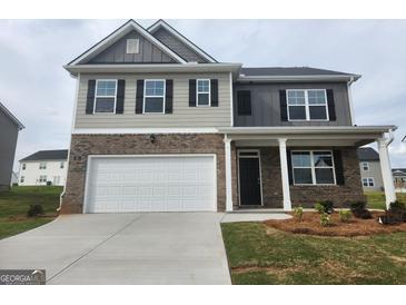 Two-story home features a two-car garage, a covered entry, and a mixed material facade, enhancing curb appeal at 161 Aster Ave, Locust Grove, GA 30248