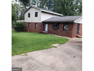 Two-story home with brick and white siding and a green lawn and concrete driveway at 1217 Dove Ct, Morrow, GA 30260