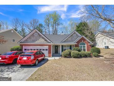 Charming single-story brick home with a two-car garage and well-maintained front yard at 2636 General Lee Ct, Buford, GA 30519