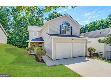 Charming two-story home with manicured lawn, lush landscaping, and two-car garage at 2940 Highland Hill Pkwy, Douglasville, GA 30135
