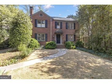 Charming brick home with black shutters, mature landscaping, and a stone pathway to the front entrance at 619 E Pelham Ne Rd, Atlanta, GA 30324