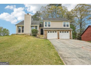 Charming two-story home featuring a two-car garage and a well-maintained front yard with mature trees at 909 Chapman Cir, Stone Mountain, GA 30088