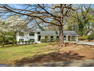Charming home with landscaped front yard, covered parking, and black framed windows, creating a welcoming curb appeal at 1146 Redan Way, Stone Mountain, GA 30088