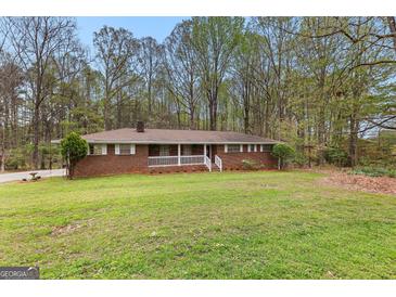 Charming brick ranch-style home featuring a lovely front porch and a spacious, well-manicured lawn at 1407 Highway 92 N, Fayetteville, GA 30214