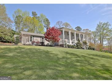 Stately two-story home with manicured lawn and a beautiful, columned front porch at 100 Smokerise Trce, Peachtree City, GA 30269