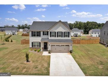 Charming two-story home featuring a well-manicured lawn and a two-car garage at 517 Daffodil Ln, Mcdonough, GA 30253