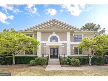 Stately two-story home featuring a symmetrical facade, manicured landscaping, and elegant double door entry at 7415 Northampton Ct, Cumming, GA 30040