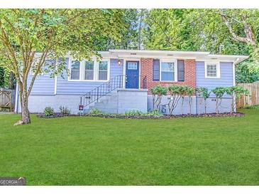 Charming single-story home with well-manicured lawn, blue siding, and brick accents offers great curb appeal at 3729 Glenwood Rd, Decatur, GA 30032