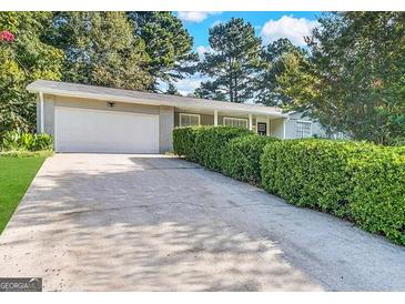 Charming single-story home featuring a two-car garage and lush landscaping at 4992 Needle Knob Ct, Lithonia, GA 30038