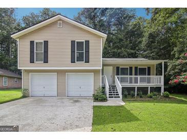 Charming home featuring a two-car garage, front porch, and a well-manicured lawn at 3980 Carlton Cove Ct, Loganville, GA 30052