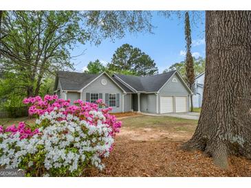 Charming single-story home with a two-car garage and beautiful flowering bushes in the front yard at 9591 Teal Ter, Jonesboro, GA 30238