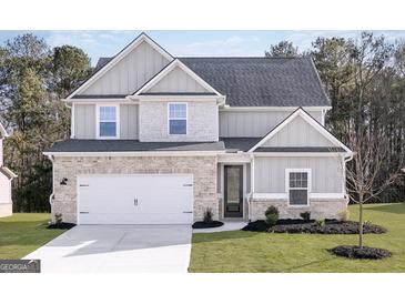 Charming two-story home with a brick and siding facade, attached garage, and well-manicured lawn at 3413 Arabian Farm Ln, Dacula, GA 30019