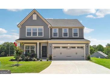 Charming two-story home featuring a gray exterior, a two car garage, and a beautifully landscaped front yard at 864 Maduro Way, Mcdonough, GA 30253