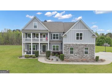 Charming two-story home with a welcoming front porch, stone accents, and manicured landscaping at 176 Butler Rd, Brooks, GA 30205