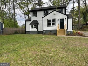Charming two-story home features a well-maintained lawn and classic black and white exterior paint at 1751 S Olympian Way, Atlanta, GA 30310