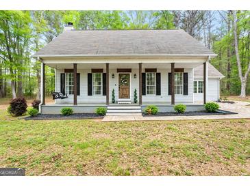 Charming single-story home with a welcoming front porch and beautiful landscaping at 105 Honey Creek Rd, Mcdonough, GA 30252