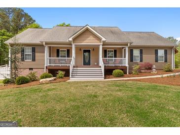 Charming single-story home with a welcoming front porch and well-manicured lawn at 155 Duncans Mill Dr, Locust Grove, GA 30248