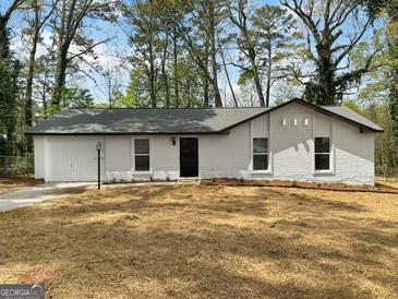 Charming single-story home with a white brick facade, attached garage, and a freshly mulched front yard at 2800 Chelsey Trl, Jonesboro, GA 30236