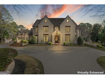 Stately home with a circular driveway, manicured landscaping, and elegant architectural details at 140 Newhaven Dr, Fayetteville, GA 30215