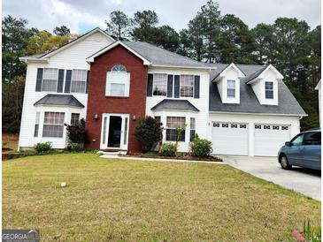Charming two-story home featuring a brick facade, three-car garage, and lush front lawn at 1592 Smithson Ct, Lithonia, GA 30058