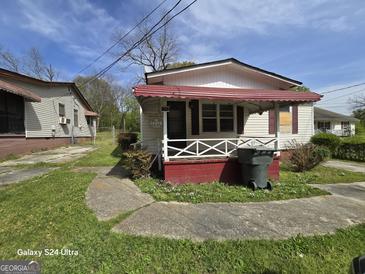 A small single Gathering home with red awning over the porch at 1243 Hill Nw St, Conyers, GA 30012