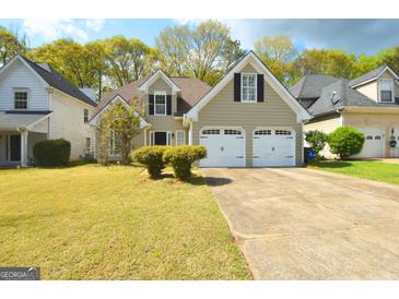Charming home features a two-car garage, well-manicured lawn, and classic design at 75 Prestwick Ln, Peachtree City, GA 30269