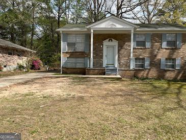 Charming brick home with a covered front porch and classic light blue shutters at 1397 Iron Gate Blvd, Jonesboro, GA 30238