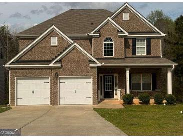 Charming two-story brick home with a well-maintained lawn and a two-car garage at 1461 Judson Way, Riverdale, GA 30296