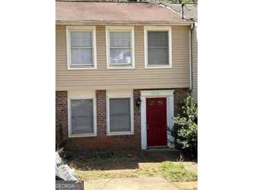 A charming townhouse with a red front door and neutral-toned siding, enhancing curb appeal at 5575 Marbut Rd, Lithonia, GA 30058