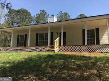 Inviting single story home with a covered porch and a well-maintained landscaped lawn at 25 Dove Pt, Covington, GA 30016