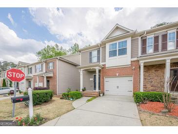 Charming townhome with brick facade, attached garage, and landscaped front yard at 2705 Maple Park Pl # 29, Cumming, GA 30041
