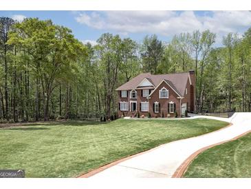 Beautiful brick two-story home with a well-manicured lawn and long driveway at 20 Allie Dr, Mcdonough, GA 30252