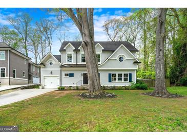 Charming two-story home featuring a well-manicured lawn, classic architectural details, and mature trees at 2940 Parkridge Ne Dr, Brookhaven, GA 30319