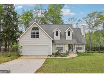 Charming home with a two-car garage, dormer windows, and a well-maintained lawn with mature trees at 2014 Big Cypress Ln, Locust Grove, GA 30248