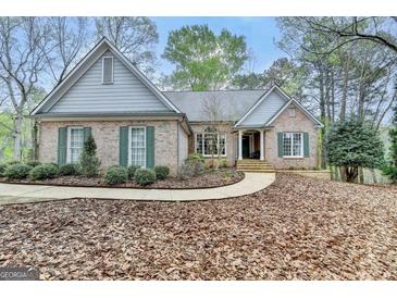 Charming brick home featuring a manicured lawn, symmetrical shutters, and a welcoming front entrance at 3230 Riverhill Ct, Cumming, GA 30041