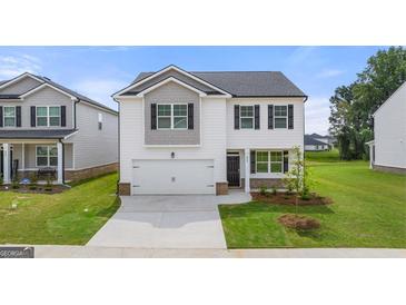 Two-story home featuring black shutters, a two-car garage, and a well-maintained front lawn at 8593 Secretariat Dr # 20, Lithonia, GA 30058