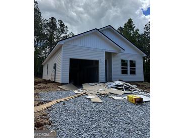 New construction home features an attached two-car garage and a white exterior, surrounded by a wooded lot at 543 Courthouse Park Dr., Temple, GA 30179