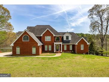 Beautiful two-story red brick home with manicured lawn and mature trees at 170 Austin Oaks Dr, Ellenwood, GA 30294
