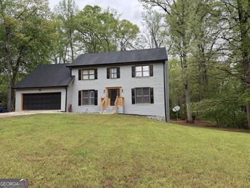 Charming gray two-story home with black shutters and a spacious front yard at 4710 Meadowlark Se Dr, Conyers, GA 30094