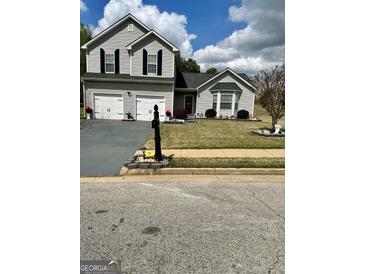 Charming two-story home featuring a two-car garage, well-maintained lawn, and inviting curb appeal at 55 Long Dr, Covington, GA 30016
