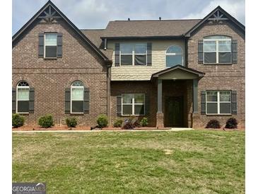 Inviting brick home featuring a manicured lawn and symmetrical design with a covered front porch at 110 Broadwater Dr, Fayetteville, GA 30214