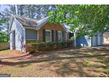 Charming home featuring a mix of brick and gray siding, complemented by a well-maintained lawn and attached garage at 9689 Pintail Trl, Jonesboro, GA 30238