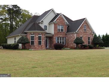 Charming two-story brick home with well-maintained landscaping and a lush front lawn at 480 Meadow Sage Ln, Fayetteville, GA 30214