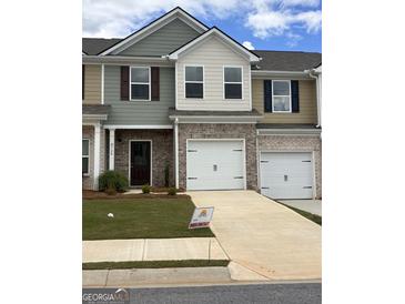 New townhome featuring a brick front, attached garage, driveway, and lawn at 8726 Lakeview Commons # 50, Jonesboro, GA 30238