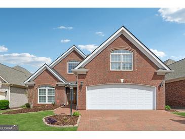 Beautiful two-story brick home featuring a brick driveway and an attached two-car garage at 1570 Woodberry Run Dr, Snellville, GA 30078
