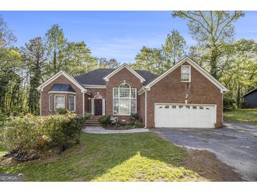 Charming single-story brick home featuring manicured lawn and attached two-car garage at 4875 Ben Hill Rd, College Park, GA 30349