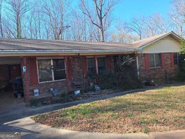Charming single story brick home with red shutters and mature trees at 1667 Park Pl, Lithia Springs, GA 30122