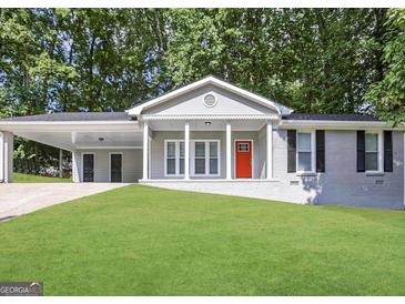 Charming single-story home featuring a covered carport, a red front door, and a well-maintained lawn at 2942 Elkhorn Ct, Decatur, GA 30034