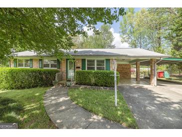 Charming brick ranch featuring a covered carport and landscaped yard at 2572 Creston Way, Morrow, GA 30260